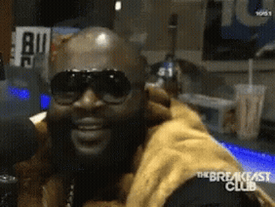 Man In Sunglasses Sitting At Microphone GIF