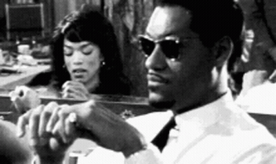 Man In Sunglasses Sitting In Front Of Mirror With Woman Looking GIF