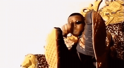 Man In Sunglasses Sitting On Chair With Lion Statue GIF