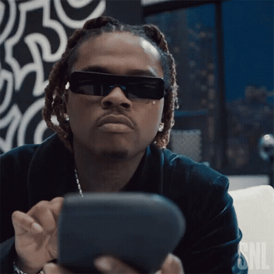 Man In Sunglasses Sitting On Couch Looking At Phone GIF