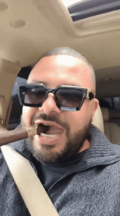 Man In Sunglasses Smoking Cigar In Car GIF