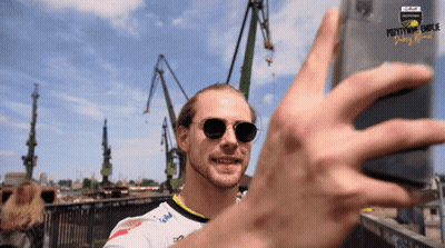 Man In Sunglasses Taking Selfie In Front Of Pottymouth Dunk Sign GIF