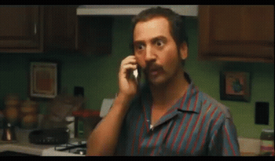 Man In Sunglasses Talking On Cell Phone In Kitchen GIF