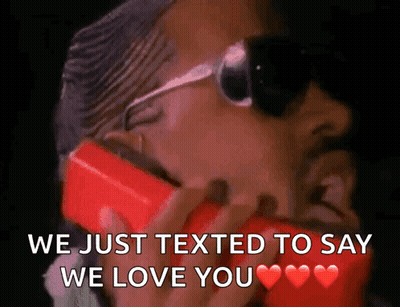 Man In Sunglasses Talking On Red Cell Phone We Just Texted To Say We Love You GIF