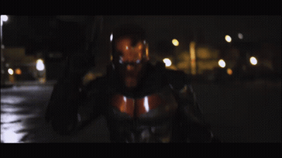 Man In Superhero Costume Holding Gun GIF
