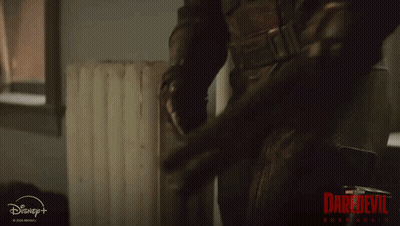 Man In Superhero Costume In Front Of Disney+ Sign GIF
