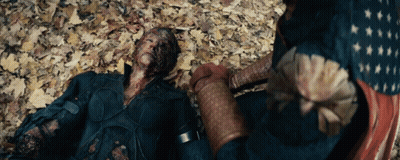 Man In Superhero Costume Laying On Ground With Leaves GIF