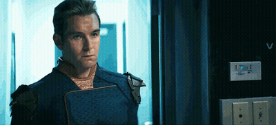 Man In Superhero Costume Looking In Hallway GIF