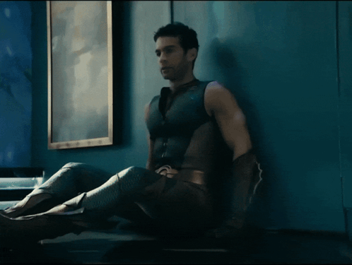 Man In Superhero Costume Sitting GIF