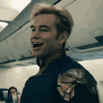 Man In Superhero Costume Sitting On Airplane GIF