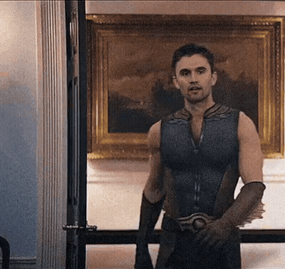Man In Superhero Costume Standing In Front Of Painting GIF