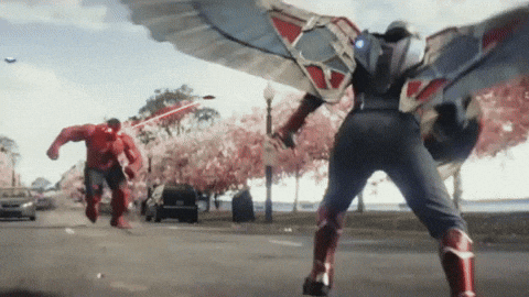 Man In Superhero Costume Walking Next To Red Hulk GIF