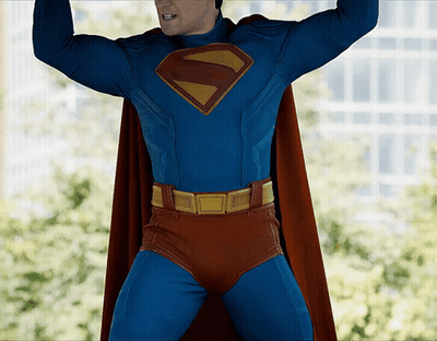Man In Superman Costume Arms Up GIF