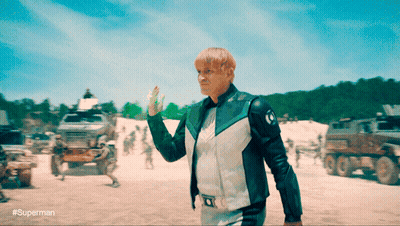 Man In Superman Costume Holding Green Object GIF