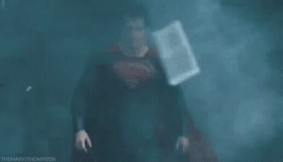 Man In Superman Costume In Dark Foggy Room GIF