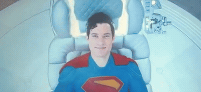 Man In Superman Costume Laying In Chair GIF