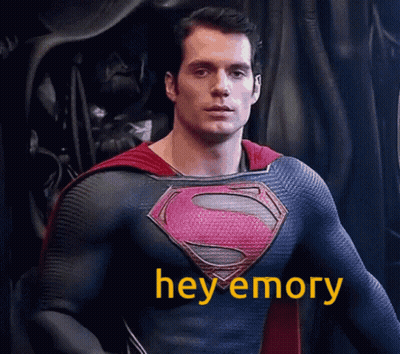 Man In Superman Costume Standing In Front Of Black Curtain GIF