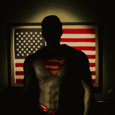 Man In Superman Suit In Front Of American Flag GIF