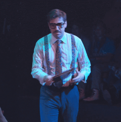 Man In Suspenders And Glasses Holding Paper GIF
