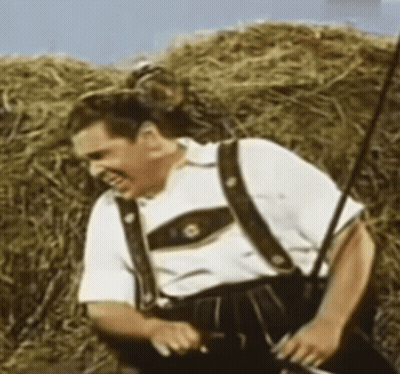 Man In Suspenders Standing By Hay Bale GIF