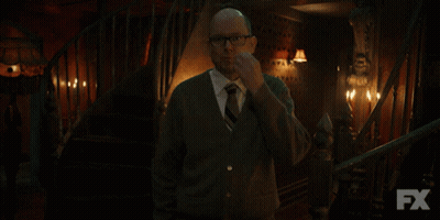 Man In Sweater And Tie In Front Of Stairs With FX GIF