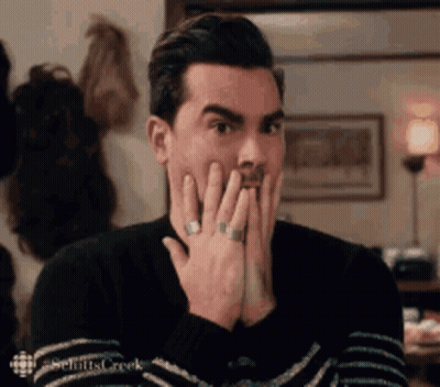 Man In Sweater Covering Mouth GIF