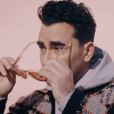 Man In Sweater Holding Sunglasses To Face GIF