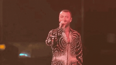 Man In Swirl Shirt Singing On Stage GIF