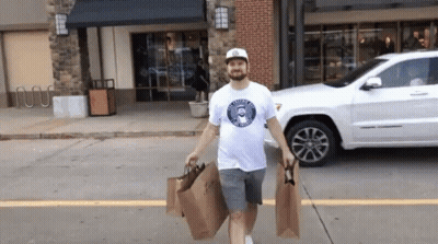 Man In T-Shirt Saying A Man Carrying Shopping Bags GIF