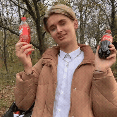 Man In Tan Jacket Holding Fanta And Coca Cola GIF
