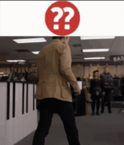 Man In Tan Jacket Walks Past Red Question Mark GIF