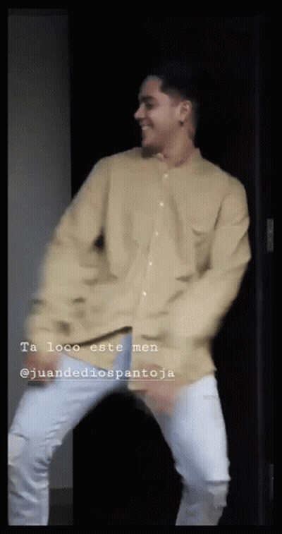 Man In Tan Shirt And White Jeans Dancing In Front Of Door GIF