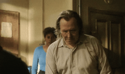 Man In Tan Shirt Standing In Front Of Woman In Blue Top GIF