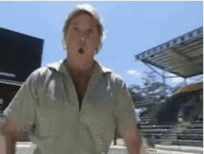 Man In Tan Shirt Surprised In Front Of Building GIF