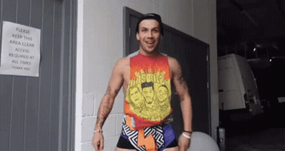 Man In Tank Top And Shorts Standing In Front Of Door GIF