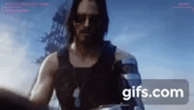 Man In Tank Top And Sunglasses Holding Gun GIF
