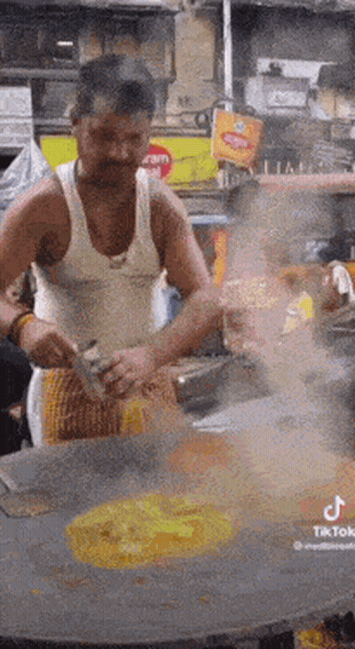Man in Tank Top Cooking on Stove
