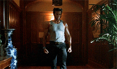 Man In Tank Top Holding Claws Out In Hallway GIF