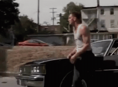 Man In Tank Top Standing Beside Black Car GIF