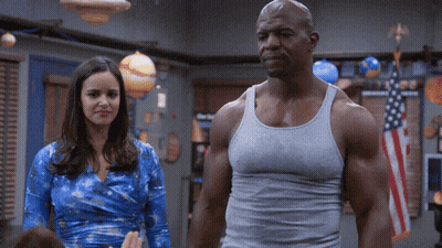 Man In Tank Top Standing Next To Woman GIF