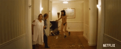 Man In Thong Sweeping Floor While Women Look On GIF