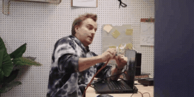 Man In Tie Dye Shirt Fixing Laptop GIF