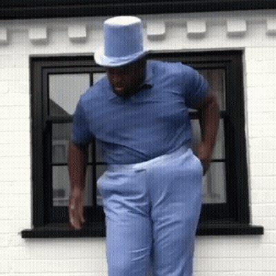Man In Top Hat And Blue Shirt By Window GIF