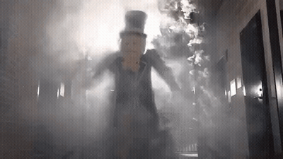 Man In Top Hat Walking Through Smoke Hallway GIF