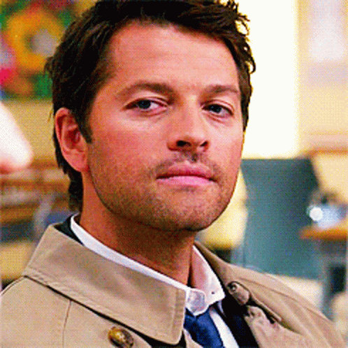 Man In Trench Coat And Tie Looking At Camera GIF