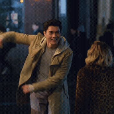 Man In Trench Coat Dancing In Front Of Woman GIF