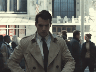 Man In Trench Coat In Front Of Calif Building GIF