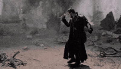 Man In Trench Coat On Dirt Road GIF