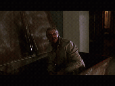 Man In Trench Coat Standing By Wall GIF