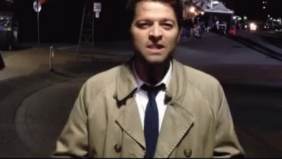 Man In Trench Coat Standing In Front Of Sign 30 GIF